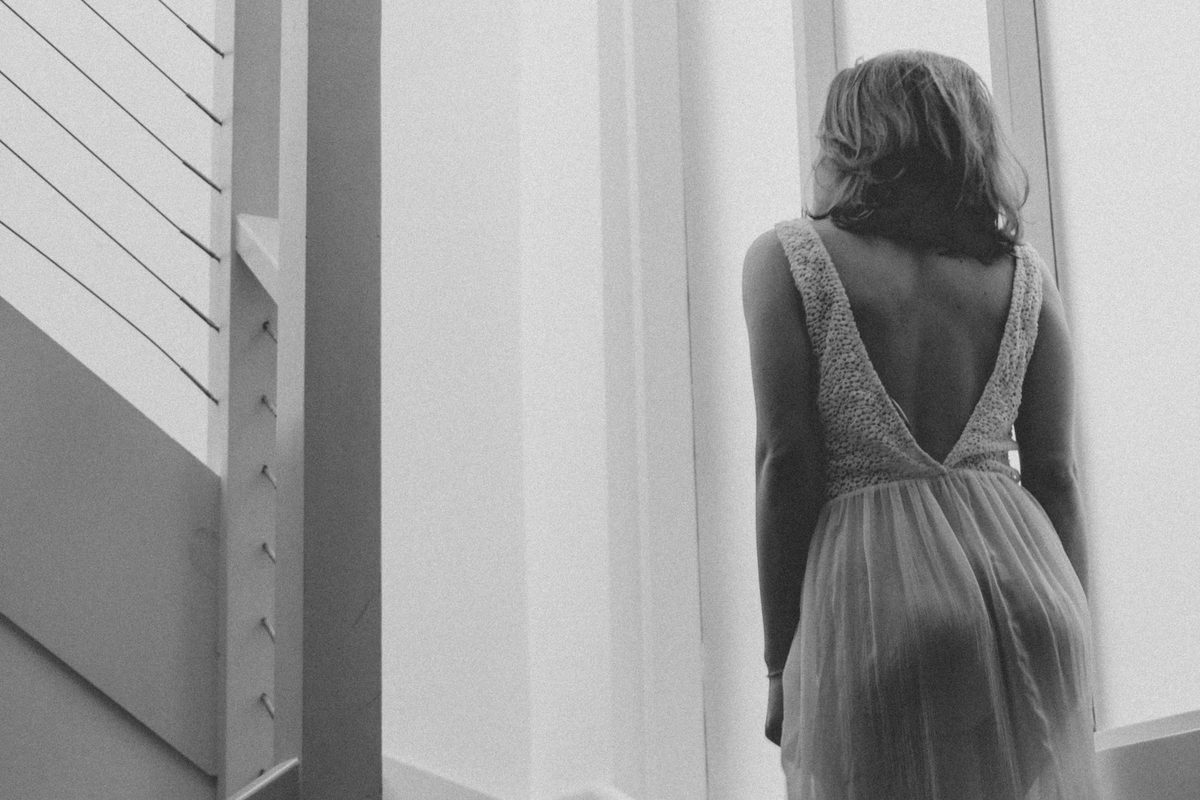 Woman standing at a doorway — the body as doorway to midlife reinvention