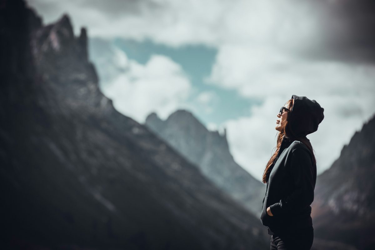 Woman looking up at mountains — purpose, legacy and generational wealth for women in midlife